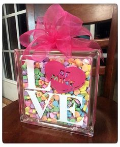 a box filled with candies and a pink bow on top of it's side