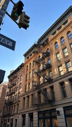 an old building is next to a street sign and traffic light in front of it