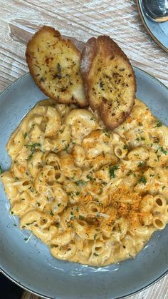 a plate of macaroni and cheese with two pieces of bread