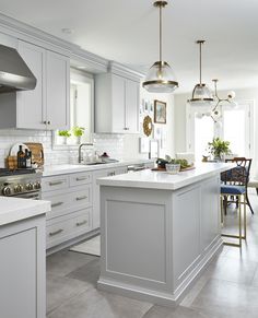 a large kitchen with white cabinets and an island