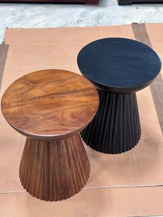 two wooden tables sitting next to each other on top of a table cloth covered ground