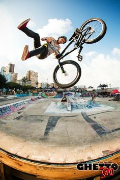 a man flying through the air while riding a bike on top of a skateboard