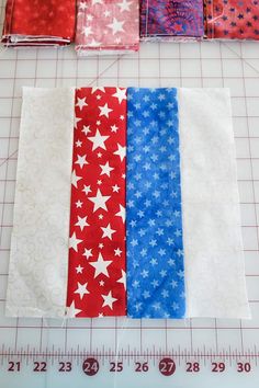 four pieces of red, white and blue fabric laid out on a cutting board