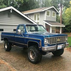 a blue truck parked in front of a house