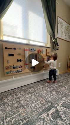 a little boy standing in front of a bulletin board with magnets and toys on it