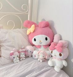 hello kitty stuffed animals are sitting on the bed