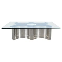 a glass and chrome coffee table with two circular sections on each side, in front of a white background