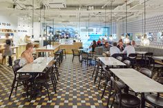 people sitting at tables in a restaurant with black and white checkered flooring