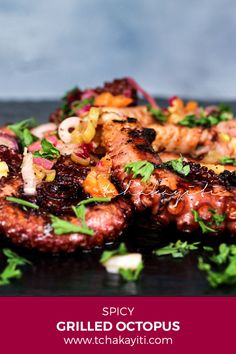 grilled octopus with vegetables and herbs on a black plate