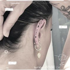 a woman wearing pink ear cuffs and piercings