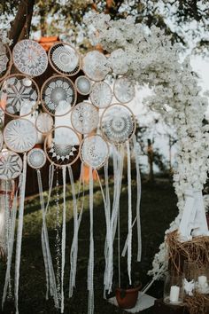 an outdoor wedding ceremony with white flowers and hanging glass plates in the shape of circles