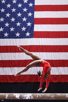 a person on a balance beam in front of an american flag