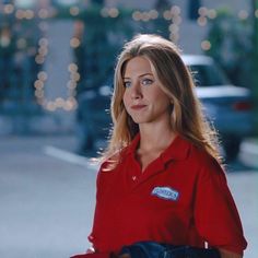 a woman wearing a red shirt and blue jeans