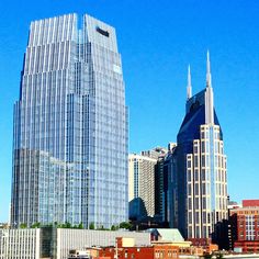 there are many buildings in the city with tall skyscrapers on each side and blue sky above them