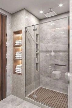 a bathroom with a walk in shower next to a wooden door and white towels on the shelves