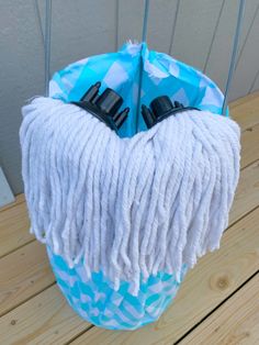 a blue and white mop sitting on top of a wooden floor