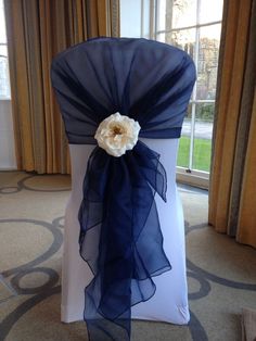 a chair with a blue sash and flower on it