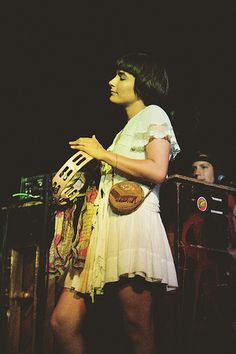 a woman in a white dress is holding a bag