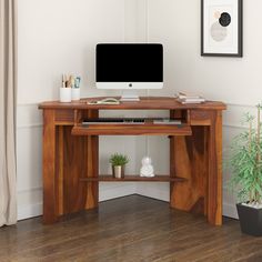 a wooden desk with a computer monitor and keyboard sitting on it's top shelf