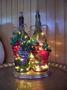 two wine bottles decorated with christmas lights