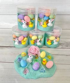 four plastic containers filled with easter decorations on top of a table