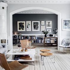 a living room filled with furniture and pictures on the wall