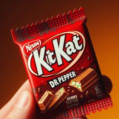 a hand holding a kitkat chocolate bar in it's wrapper with the word dr pepper on it