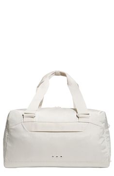 Tonal hardware and subtle branding distinguish a duffle bag that's designed with an internal shoe comaprtment and an external  trolley strap for easy carrying. 11"H x 10"W x 19.75"L Interior zip compartment Exterior trolley strap Polyester Imported Functional White Travel Bag With Adjustable Strap, Functional White Bags For Trip, Beige Rectangular Functional Duffle Bag, White Functional Weekender Bag With Luggage Sleeve, Functional White Weekender Bag For Weekend Trips, Functional White Weekender Bag For Trips, Functional White Duffle Bag, Functional White Tote Duffle Bag, White Functional Duffle Bag For Weekend Trips