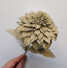 a hand holding a piece of paper that looks like a flower