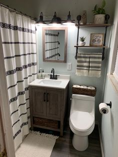 a bathroom with a toilet, sink and shower curtain