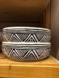 two bowls sitting on top of a wooden shelf