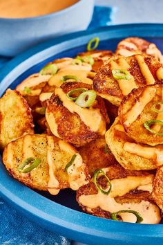 a blue bowl filled with fried food on top of a table