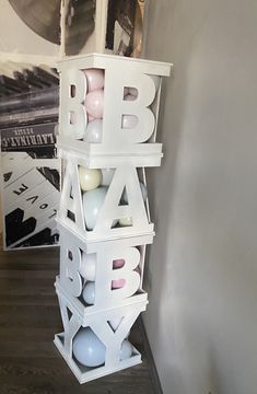 a stack of plastic letters sitting on top of a wooden floor next to a wall