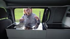 a man standing in the back of a truck looking at something on top of it