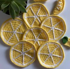 crocheted lemon coasters are arranged on a table