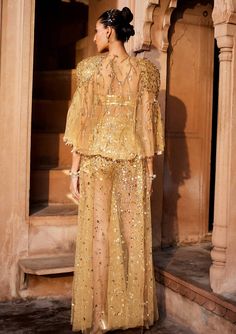 A bold three piece dress in sheer fabric, a glamorous embellished gold bralet paired with sheer trousers with splatter embroidery of sitara/patra and a matching sheer jacket with power shoulder highlighted with gold embellishments Indian Wedding Dress Traditional, Three Piece Dress, Gold Bralette, Net Jacket, Indo Western Outfit, Pant Top, Sheer Jacket, Set Saree, Saree Gown