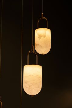 three lights hanging from the ceiling in a dark room