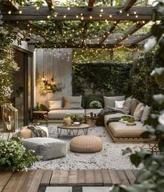 an outdoor living area with couches, tables and lights