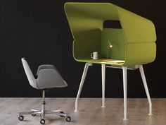 an office chair and table with a laptop on it in front of a black wall