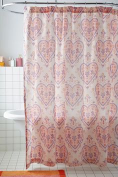 a bathroom with a shower curtain that has hearts on it