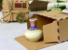 a vase sitting inside of a cardboard box on top of a table next to other boxes