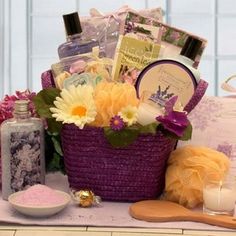 a purple basket filled with lots of different items next to a candle and some flowers