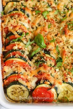 a casserole dish filled with zucchini, tomatoes and other veggies