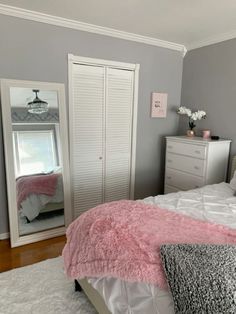 a bedroom with gray walls and white furniture