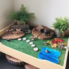 a wooden table topped with fake animals and plants