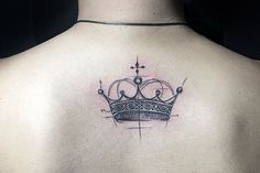 a crown tattoo on the back of a woman's upper body is shown in black and grey