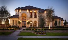 a large house with lots of windows and lights on it's front lawn area