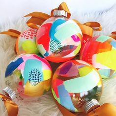 several colorful ornaments are sitting on a white furnishing area with ribbon around them