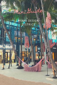 there is a hammock hanging between two palm trees in front of the miami design district