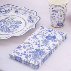 a table topped with blue and white plates and cups